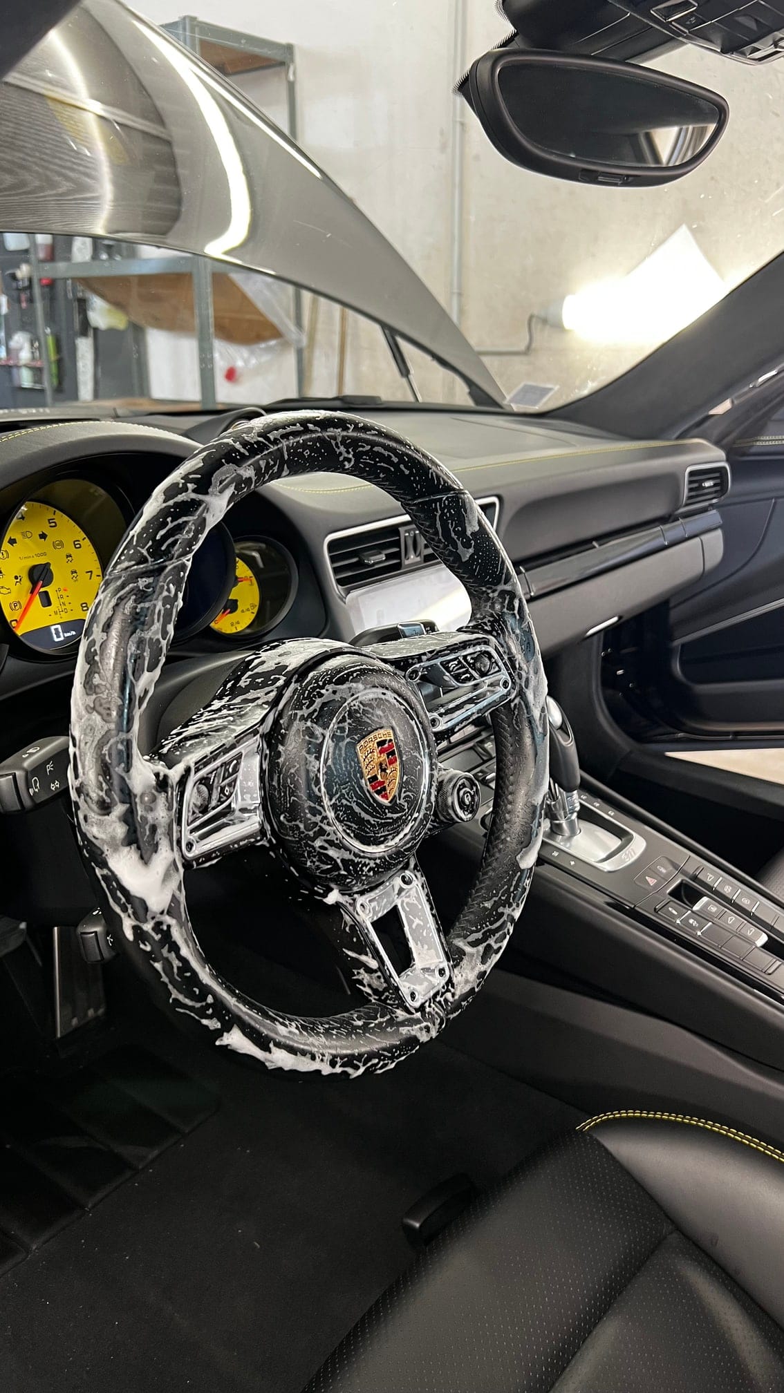 Nettoyage du volant d'une Porsche 911 à la mousse, en intervention à domicile